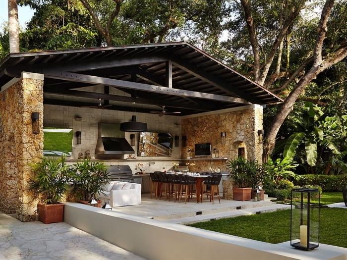 nápad na krytú letnú kuchyňu so strechou z masívu a kamennou stenou, dispozícia záhrady s jedálenským stolom