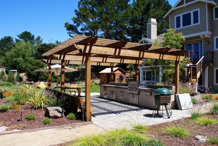 nápad, ako zariadiť letnú kuchyňu na záhrade s masívnou strechou a betónovými a nerezovými modulmi