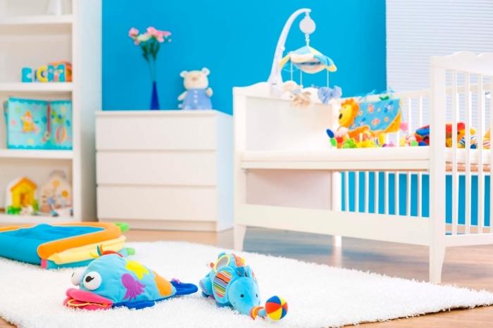 chlapčenská dizajnová spálňa s modro namaľovanými stenami a bielo natretým dreveným nábytkom pre novorodeneckú izbu