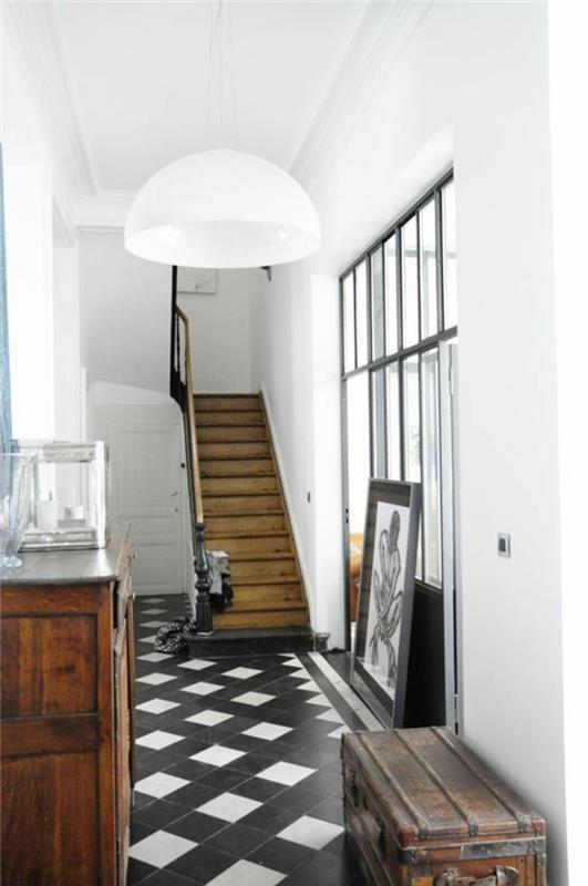 pekná retro-elegantná chodba s čierno-bielymi kachľovými podlahami, bielymi stenami a dreveným schodiskom