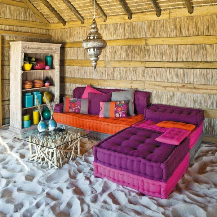 غرفة معيشة-مغربية-خارجية-مع-أثاث-بنفسجي-أرجواني-أريكة-على-الرمل-والزجاج-و-طاولة-خشبية