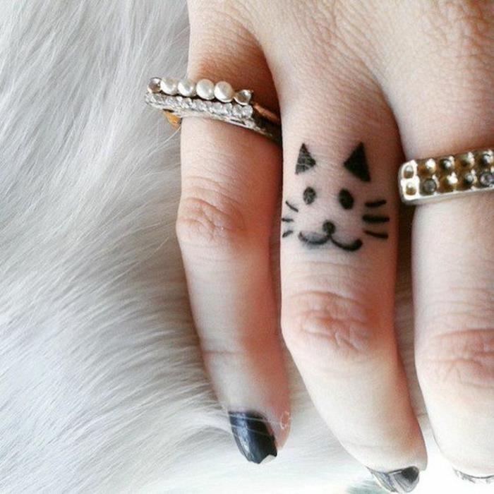 en bedårande tatuering på fingret med ett kattmotiv, enkel design och