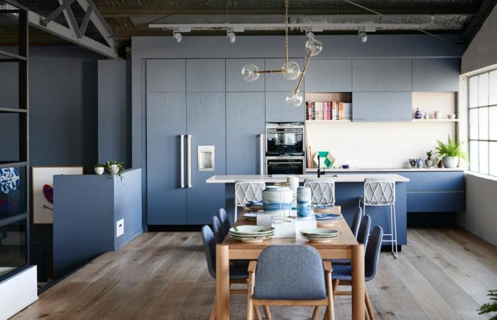 خشب وأزرق في المطبخ ، طاولة طعام خشبية ، مصابيح جزيئية ، أرضية خشبية