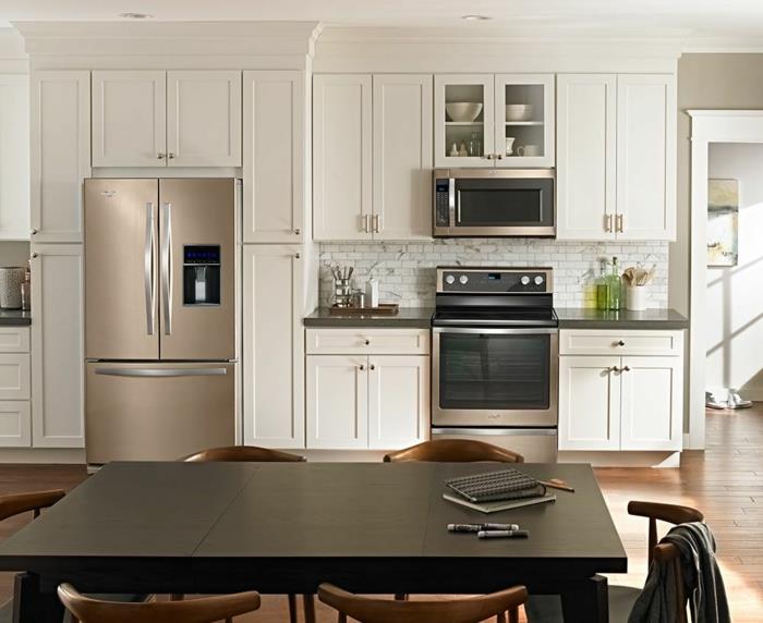 stort svart bord, trästolar, modernt kylskåp, kök, vägg med inbyggd förvaring
