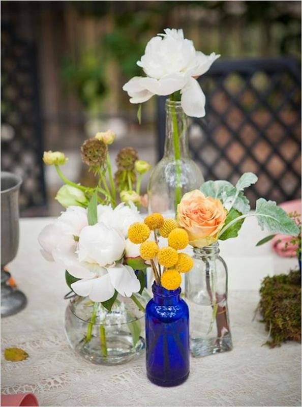 vacker-dekoration-på-bordet-med-glas-vaser-blommor-i-de-transparenta-vaserna