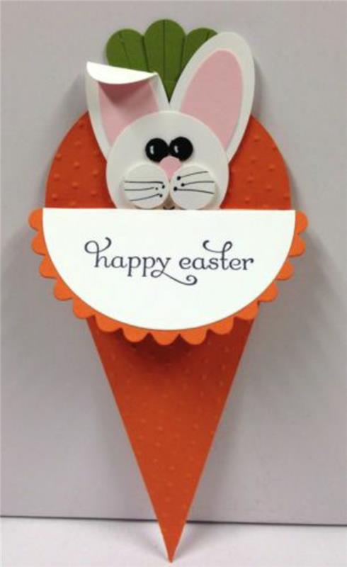vit påskhare, rosa öron, i en orange papper morot, original glad påsk kort idé, våren manuell aktivitet
