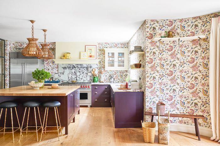 Fialový ostrov v dvojfarebnej kuchyni s kvetinovým maľovaným papierom a drevenými detailmi, maľba v jedálni s pripojenou kuchyňou