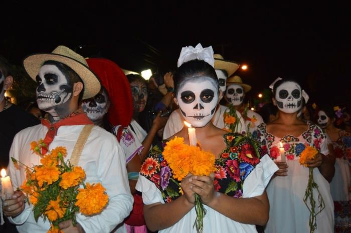 deň mŕtvych v Mexiku, Mexičania oblečení na večierok, žlté kytice, zapálené sviečky a líčenie lebky
