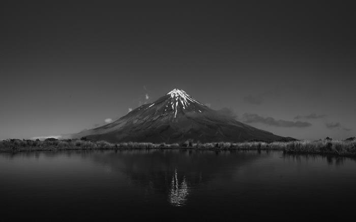 foto av en snötäckt vulkan reflekterad i sjöns vatten, för att tryckas som en svartvit affisch