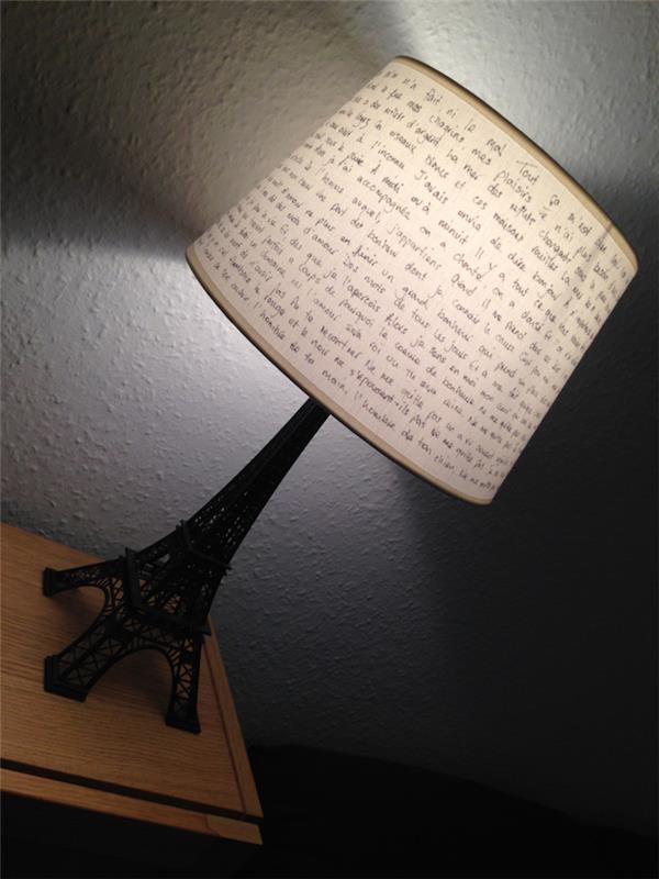 sovrumsinredning, svart Eiffeltornsfigur, sänglampa med inspirerande citat