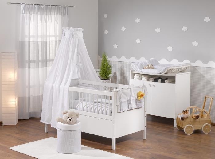 pokojná atmosféra s bledosivou tapetou s bielymi 3D kvetmi v novorodeneckej izbe s veľkým oknom