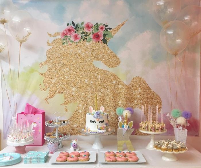 idé för arrangemang och flickaktigt utsmyckning av en dessertbuffé för en enhörningsfödelsedag i rosa och guld