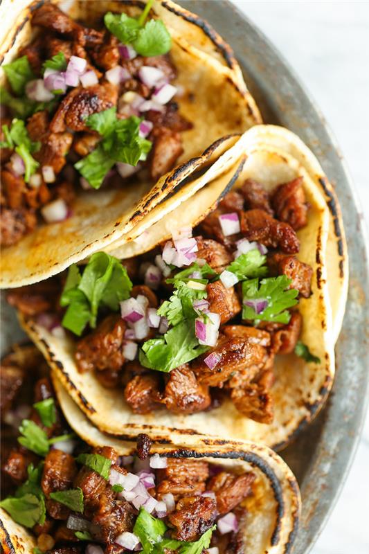 Piatti messicani, tacos con carne, prezzemolto tritato, piatto con tortillas