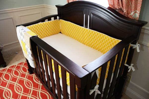 drevená posteľ so žltým a bielym matracom