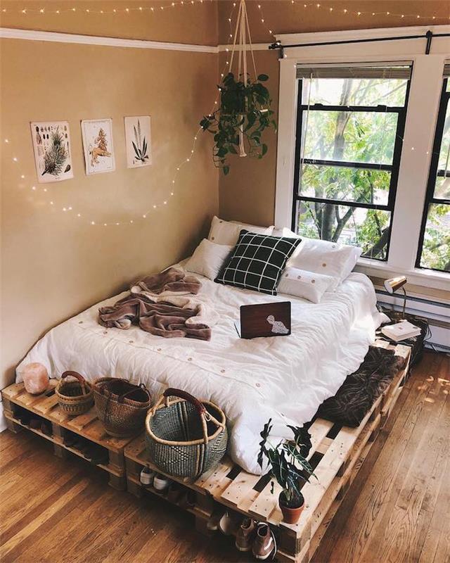 Krásne zdobená spálňa Tumblr, paletová posteľ, dekoratívne tenisky, interiér, hipsterská výzdoba spálne pre teenagerov, svetelný veniec na streche