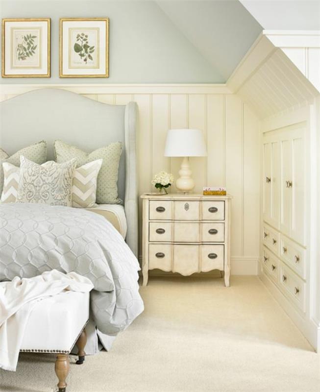 vinden sovrum, lcair grå väggfärg, grå säng och sängkläder, vintage nattduksbord med lådor, vitt underskåp, väggdekoration, vit matta, vintage sängänd