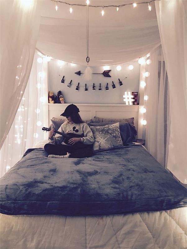 Akú výzdobu spálne pre teenagerov si vybrať, spálňu Tumblr s množstvom svetelných girlandov, dievča hrajúce na gitare sediace na svojej útulnej posteli