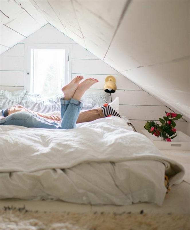 sängmadrass placerad på golvet, gråvit matta, vita sängkläder, vinds layout, vindsrum, växt, vit väggfärg