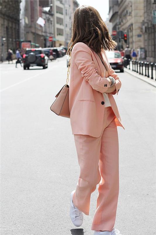 maskulin feminin look i flytande kvinnas outfit i pulverrosa färg kombinerat med vita sneakers för en avslappnad och elegant silhuett