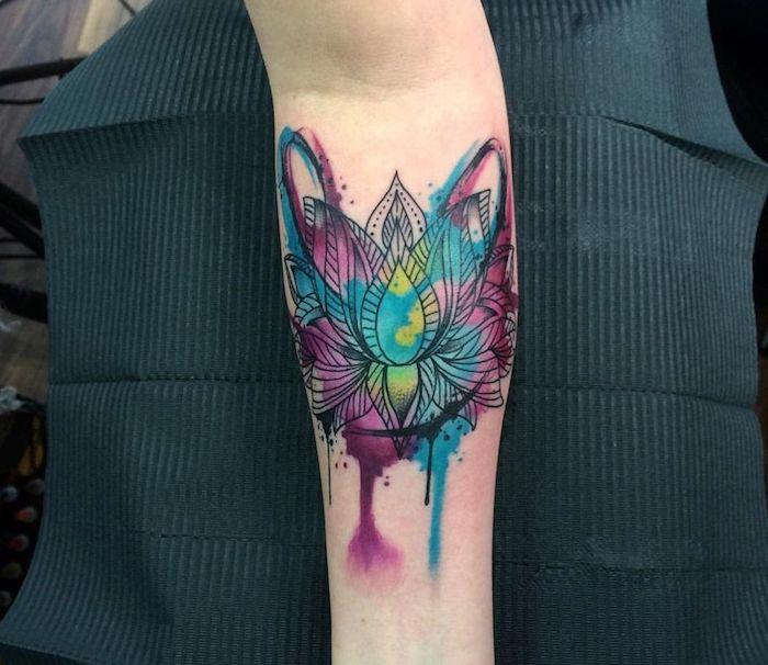 akvarell lotusblomma, tatuering under ärmarna, hand på svart papper
