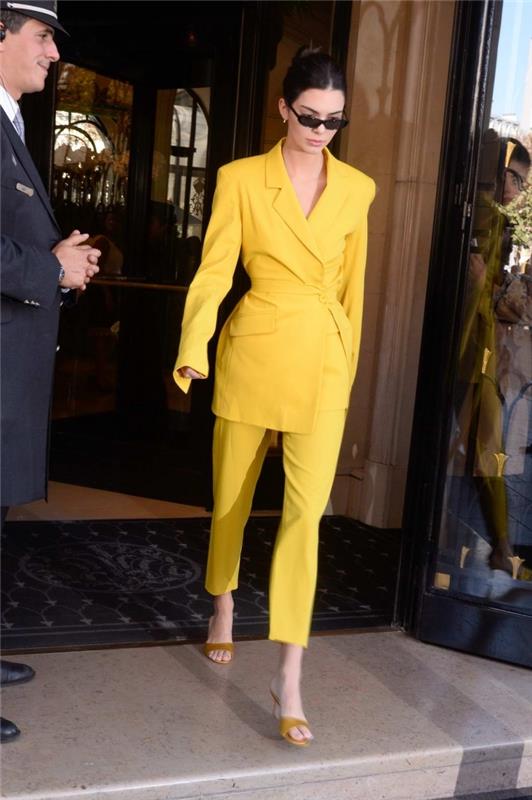 kvinnans gul kostymmodell med medellång kavaj och byxor med fotled, tillbehör till solglasögon