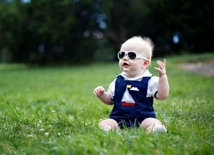 نظارة شمسية-طفل-صغير-جلوس-طفل-صغير-أخضر-عشب-تغيير الحجم