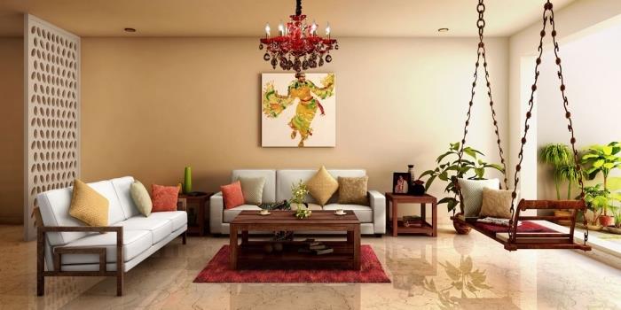 Interiér v etnickom štýle v béžovej obývacej izbe zariadenej pohovkami a exotickou hojdačkou pokrytou vankúšmi