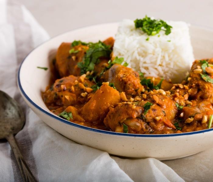 فكرة طبق تقليدي من المطبخ الأفريقي مصنوع من زبدة الفول السوداني مع مقبلات من الأرز الأبيض والأعشاب الطازجة
