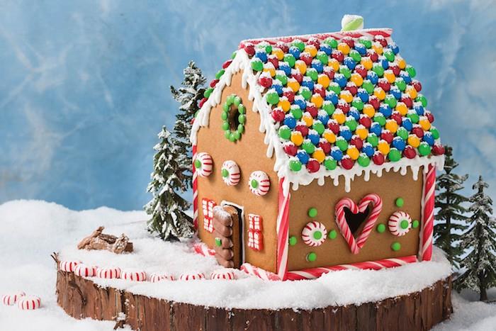 mm godis för att dekorera taket på ett litet hus, små kakor, sockergodis, gourmet dekorativ komposition på en trä stock