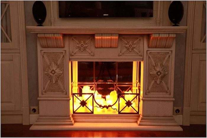 snidad dekorativ eldstadimitation med uppsättning dekorativa ljus i faux eldstilinsats med väggmonterad TV