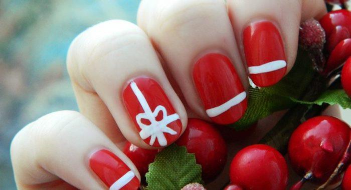 ľahké vianočné zdobenie nechtov, červený lak na nechty so vzorom bielych čiar a prázdnou stuhou, červená cezmína