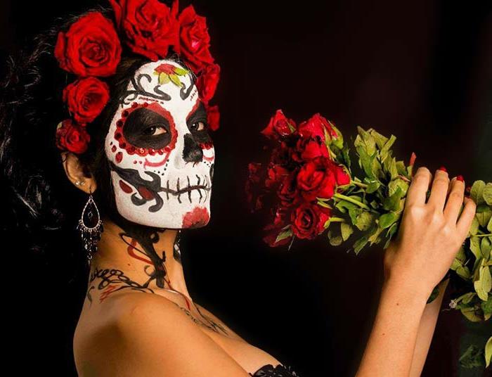 žena vynahradená na karneval mŕtvych v Mexiku, veniec z ruží, kytica ruží, líčenie kostry a halloween