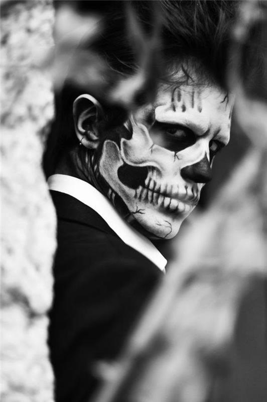 man skelettsmink, kostym, uttalade tänder och skallekonturer, skrämmande halloween -smink