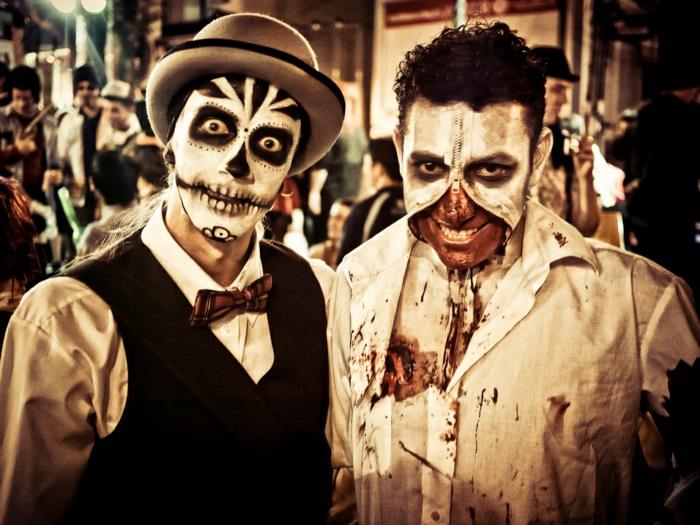 två män i halloween -smink, blekta ansikten, dragkedjefärgad mask, blodfärgade dräkter