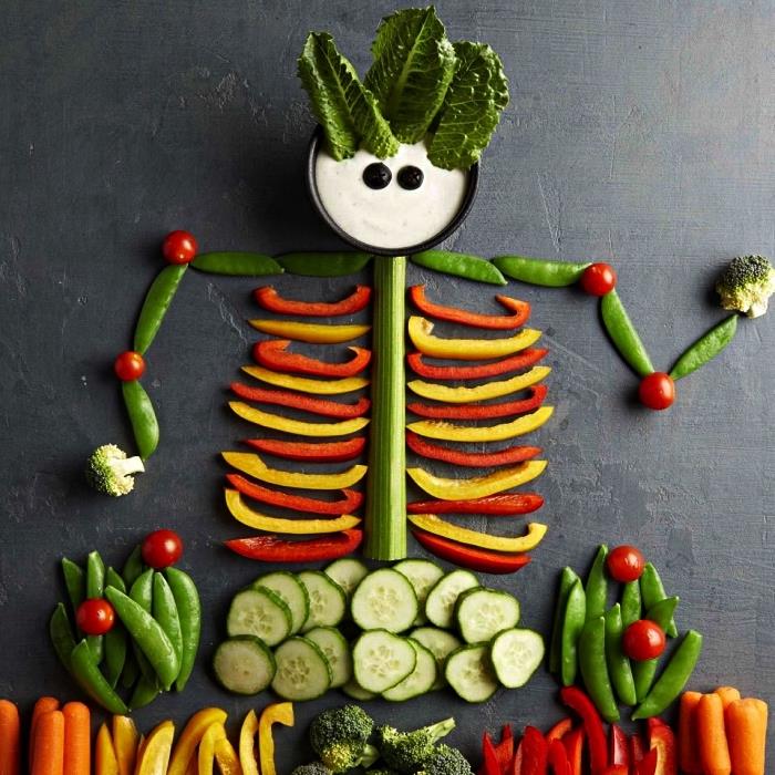 skelettformade råa grönsaksfat med aptitretarsås, aperitifidé med halloween-tema