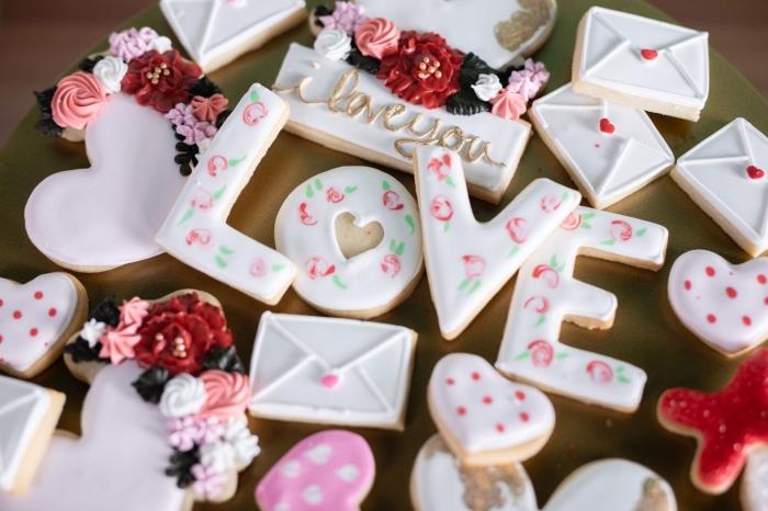 jedlé dekorácie na valentínsku párty vo forme maslových sušienok s bielou polevou s kvetinovými vzormi