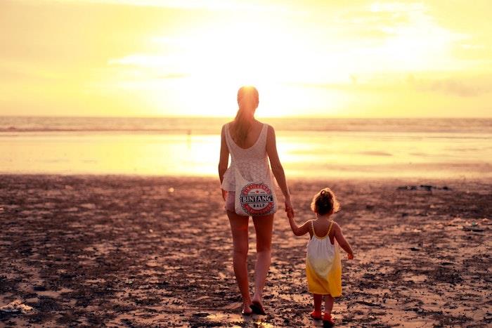 Matka a dieťa pri mori, krásna fotka pri západe slnka, text na deň matiek, šťastný deň matiek, kvety na večierok