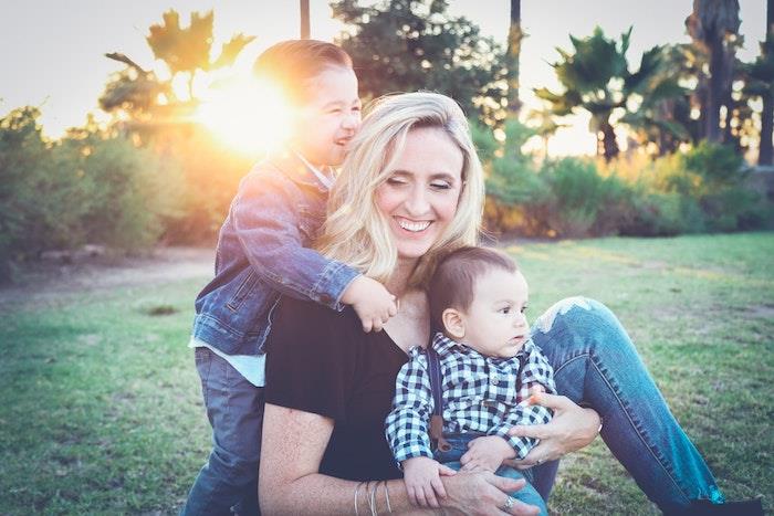 Žena so svojimi dvoma synmi v záhrade, fotografovanie matky a syna šťastný deň matiek, pohľadnica ku dňu matiek, blahoželanie s kvetmi