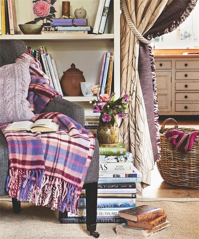 biblioteksskåp bredvid bokhylla med blomma vas och grå soffa med färgad filt och lila mesh kudde rotting förvaringskorg