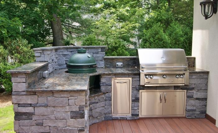 kuchynský model zariadený na terase s hnedými drevenými podlahami s kamenným ostrovom a grilom z nehrdzavejúcej ocele
