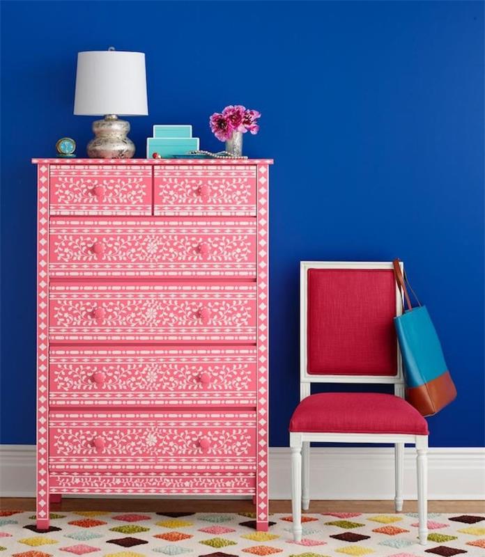príklad, ako prispôsobiť kus nábytku šablónou, bielymi kvetinovými vzormi a farbou na biely nábytok, tmavomodrú stenu, červenú stoličku