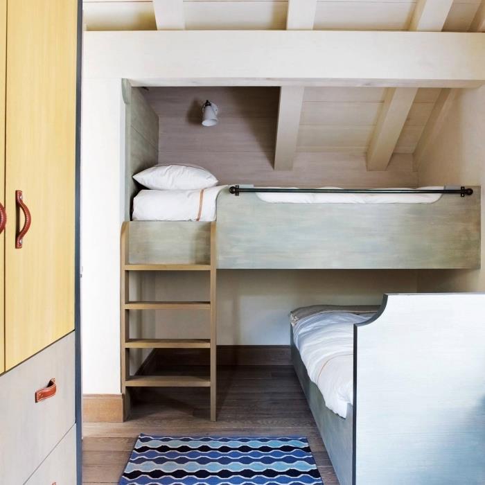 ett barns sovrum med sluttande tak med en mezzaninesäng i en underbacke, en möbel under lutningen för ett sovrum