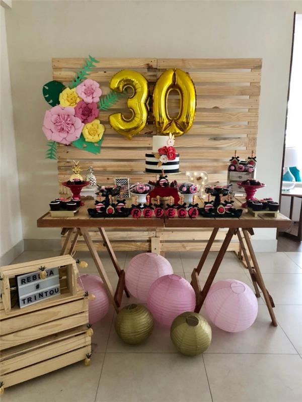 30 år gammal inredning för att göra dig själv för en fest hemma, festhörna med DIY -pallvägg dekorerad med åldersballonger och pappersblommor