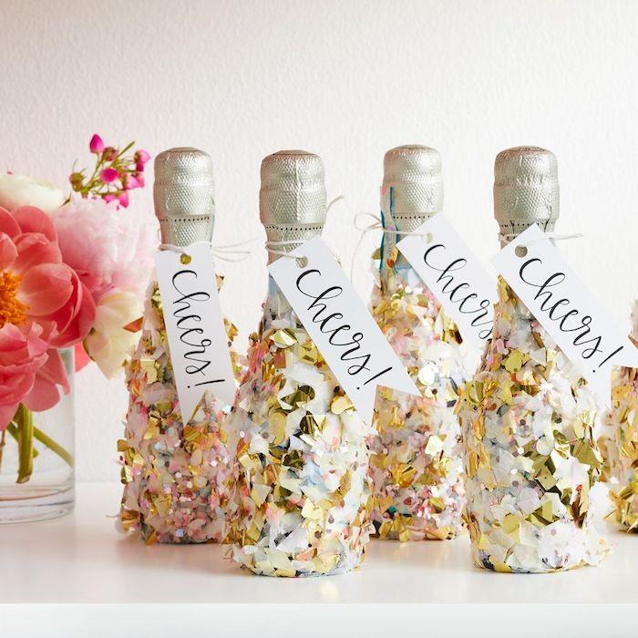 mini champagneflaskor dekorerade med konfetti med hälsotikett. liten bukett blommor, dekoration nyår 2020