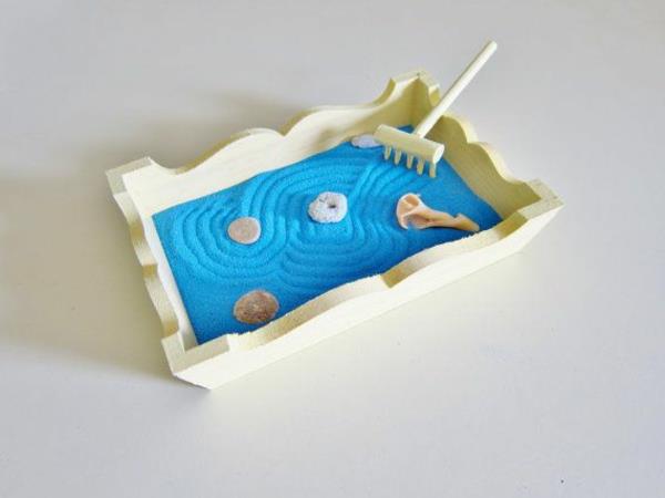 mini-zen-trädgård-med-blå-sand-och-en-rake