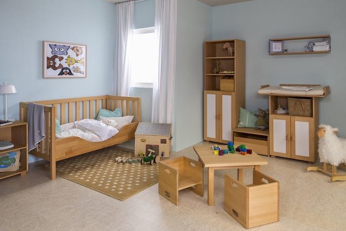 model detskej izby s pastelovo modrými stenami a novorodeným nábytkom zo svetlého dreva na béžovej podlahe