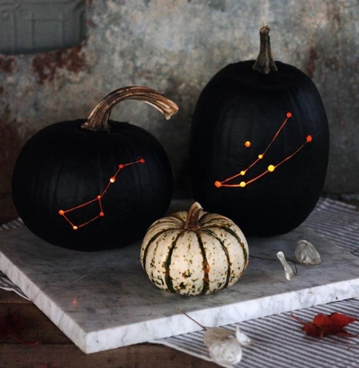 halloween manuell aktivitet, stora svartmålade pumpor med lysande konstellationer