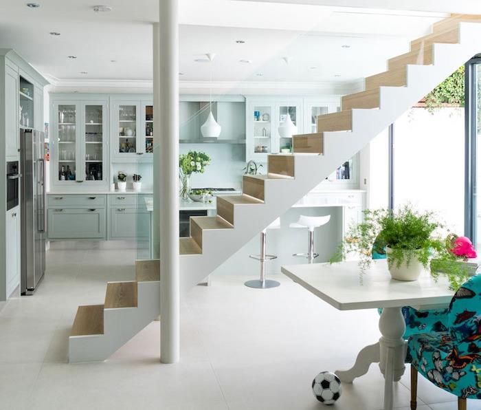 oddelená kuchyňa obývačka po schodisku, kuchyňa pod zemou, mäta zelená fasáda, biely bar so štýlovými stoličkami