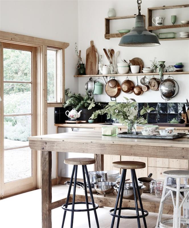 ديكور ريفي مع خزانة مطبخ خشبية ورفوف خشبية مفتوحة ومنضدة خشبية وبلاط أسود وأواني مطبخ باللون الأبيض والنحاسي والخشب