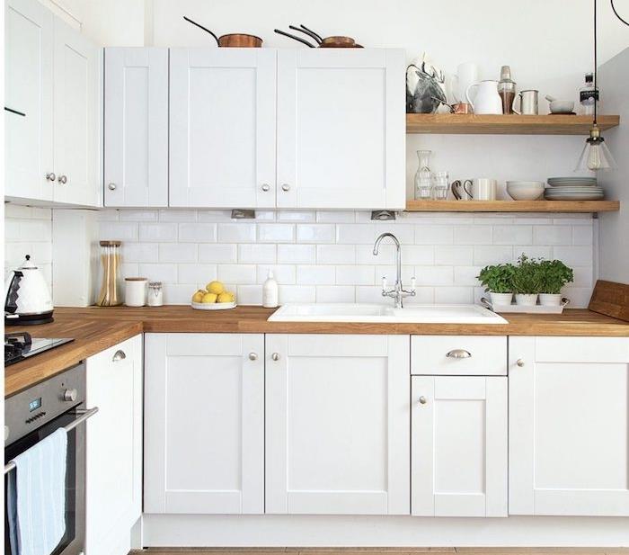 exampel trä och vitt kök dekorerat med vita möbler med bänkskiva i trä och vita kakelplattor, öppna trähyllor, porslin